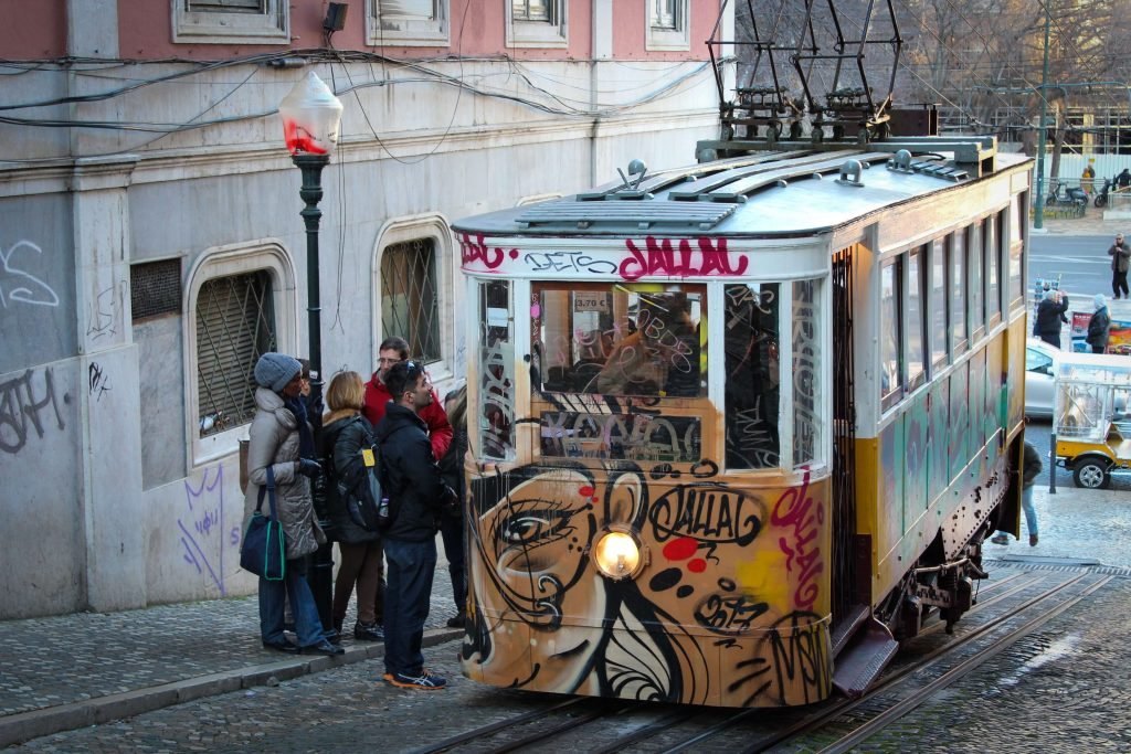 Tourists bundled up against the winter chill waiting to board the historic yellow Lisbon tram.
