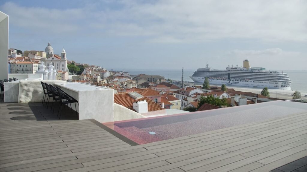 View of the Tagus River with a cruise ship docked from the rooftop terrace of a hotel.