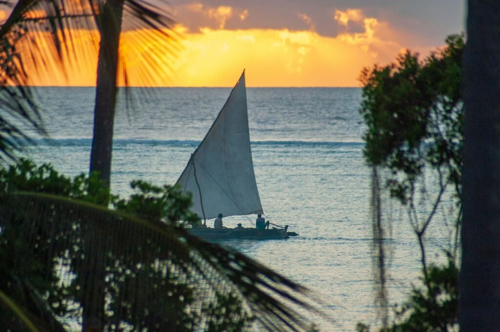 A traditional Zanzibar dhow heading out into the ocean at sunrise.