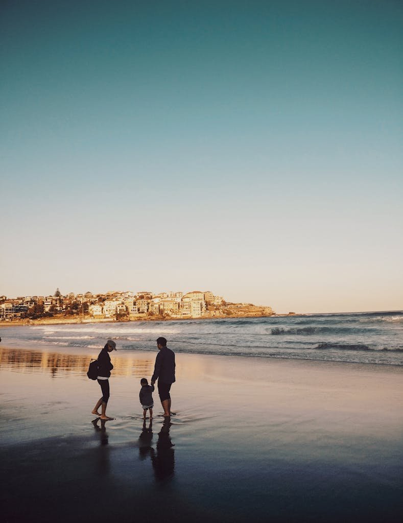 Man and Woman Walking With Boy in Seashore - family travel quotes