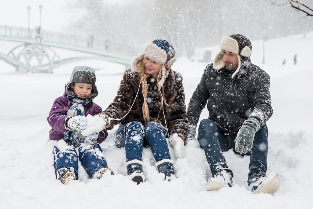 Woman, Man and Girl Sitting on Snow - family travel quotes