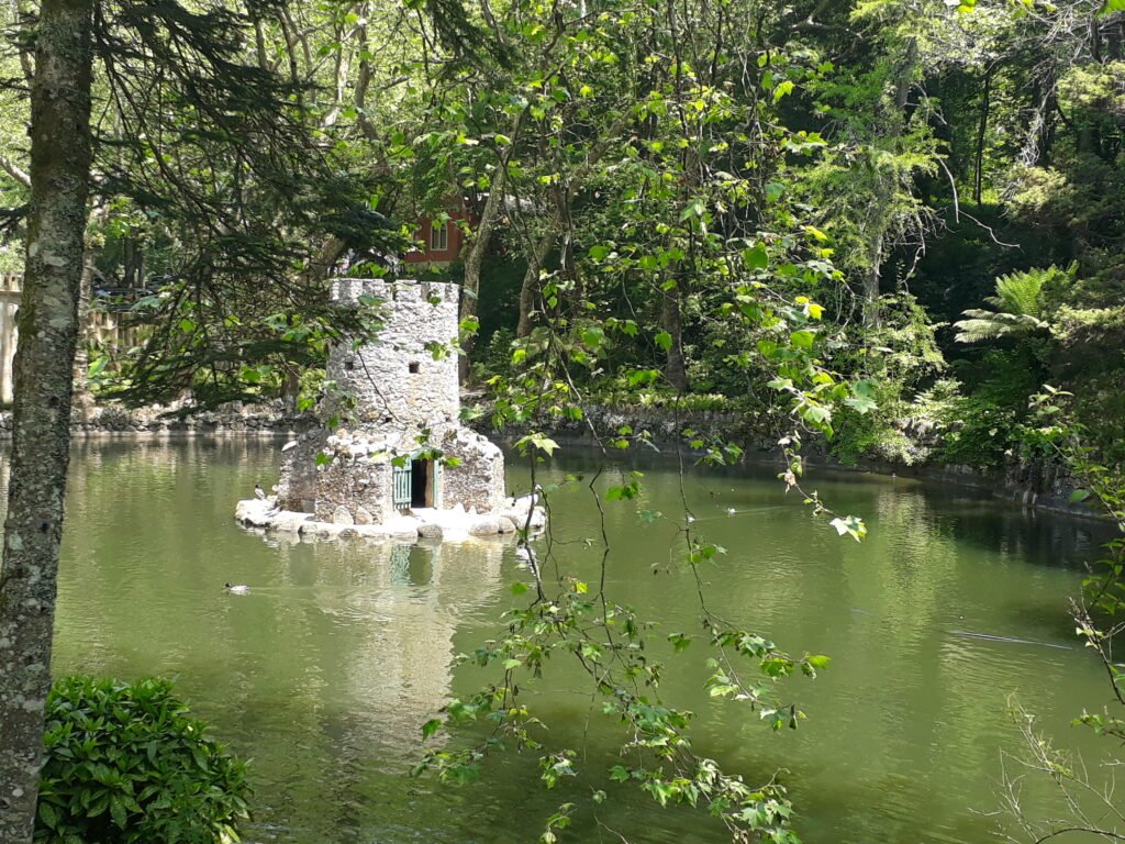 A mini castle in the middle of a pond in Pena Palace Gardens.