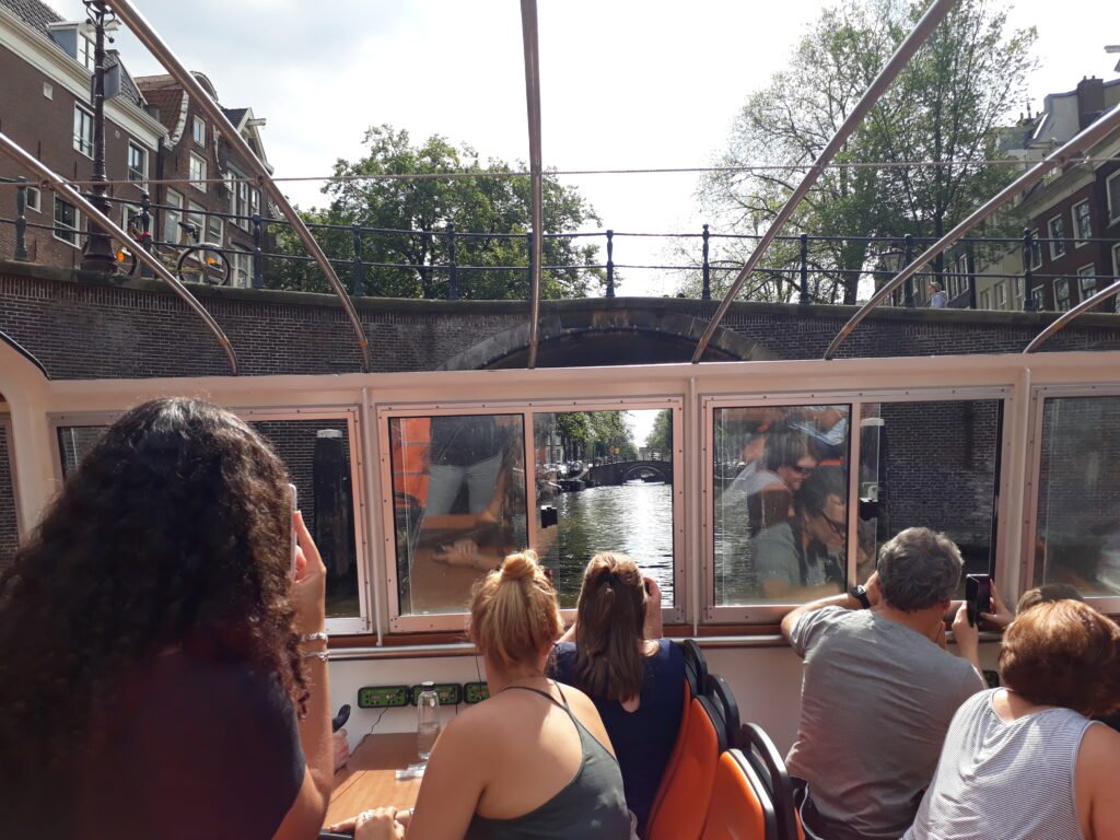People sitting on a boat in a canal in Amsterdam.