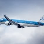 KLM aircraft flying through a cloudy sky, showcasing aviation and travel.