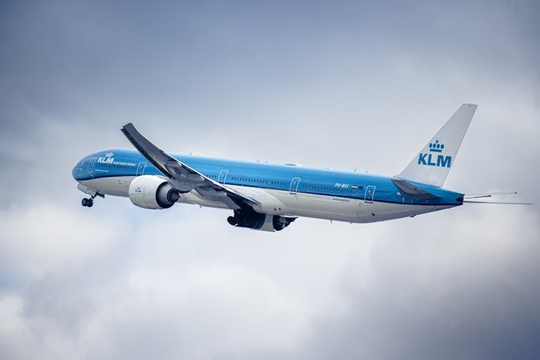 KLM aircraft flying through a cloudy sky, showcasing aviation and travel.