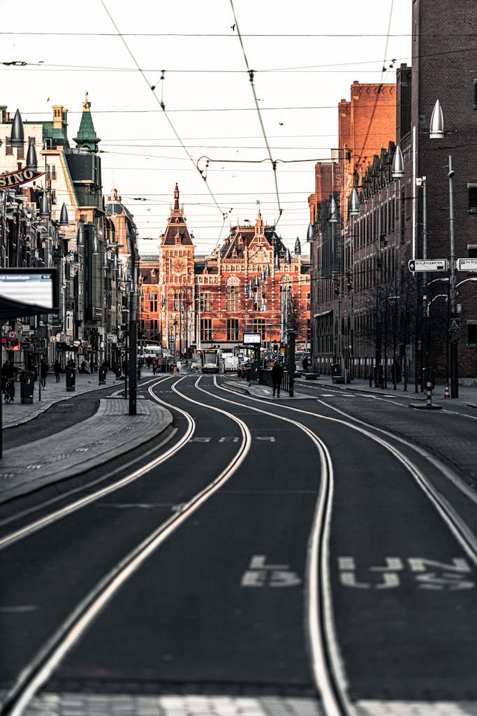Urban scene with tramlines leading to Amsterdam Central Station during daytime.