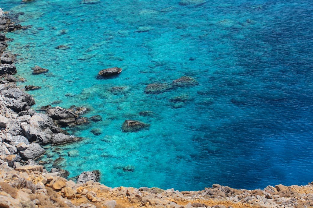 Crystal-clear turquoise waters and rocky coastline in Rethymno, Greece, perfect for travel inspiration.