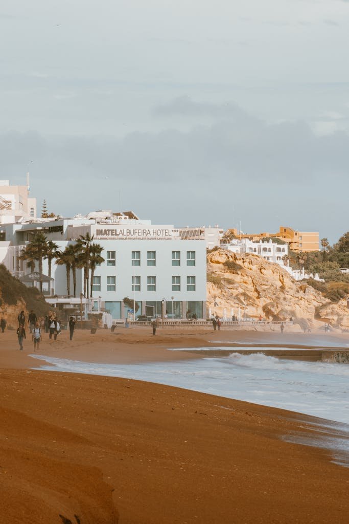 Scenic view of Albufeira beachfront with hotel and waves, perfect for a relaxing getaway.