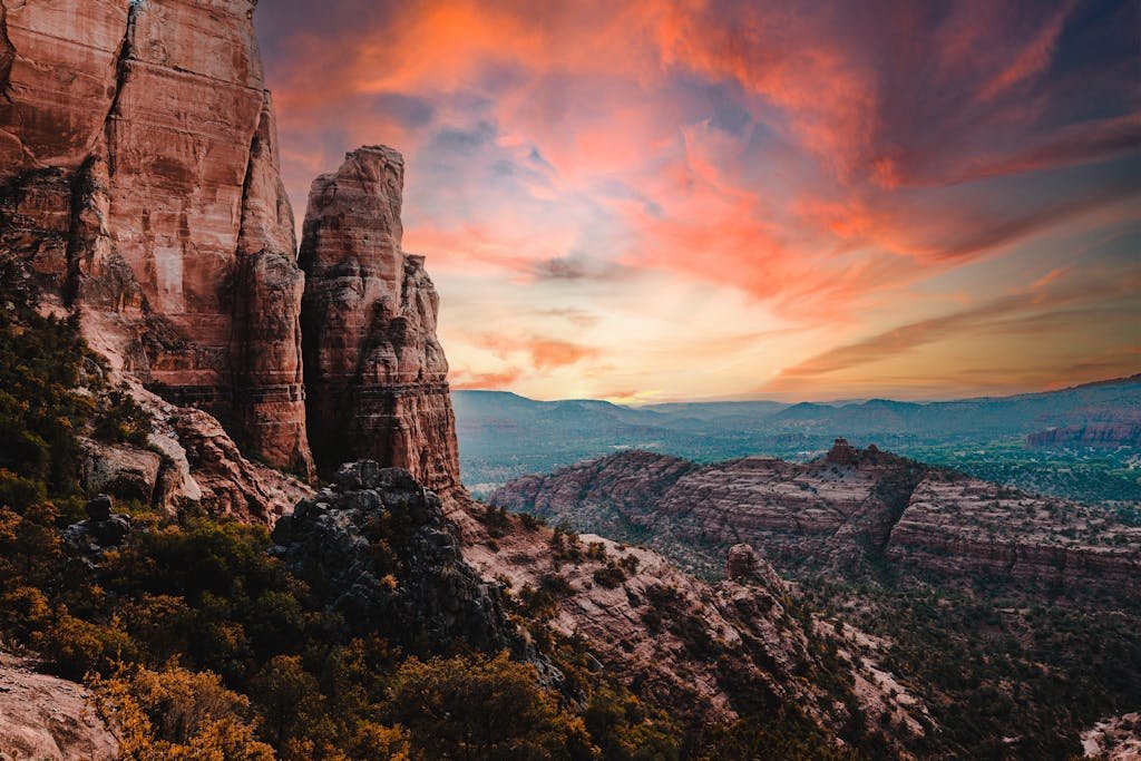 Breathtaking view of Sedona's red rock formations under a vibrant sunset sky, capturing nature's beauty.
