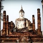 Serene Buddha statue surrounded by ancient pillars in Ayutthaya, Thailand, showcasing timeless beauty and cultural heritage.